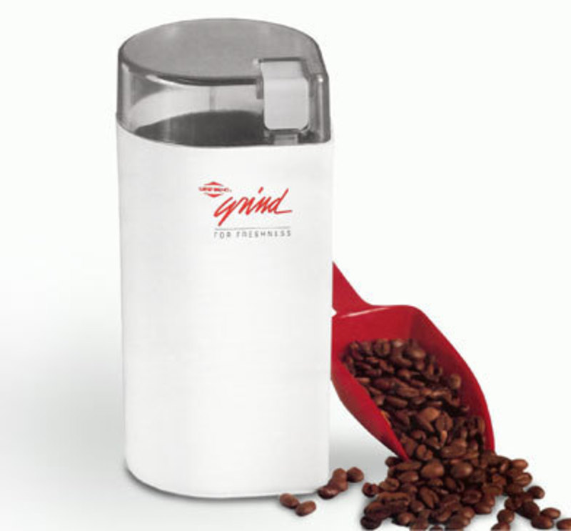 Three quarters front view of the singles grinder with a scoop of coffee