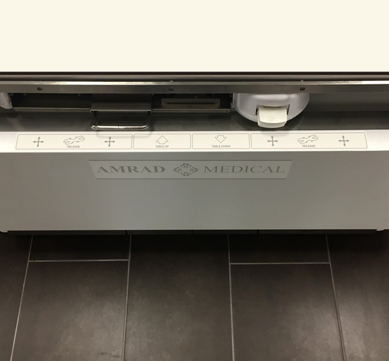 Summit Industries: Advantage DFMT for AmRad Medical Close up view of the DFMT's floor pedal instruction decal on the lip of the front steel cover