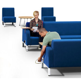 Context view showing people using charging ports on Bretford furniture